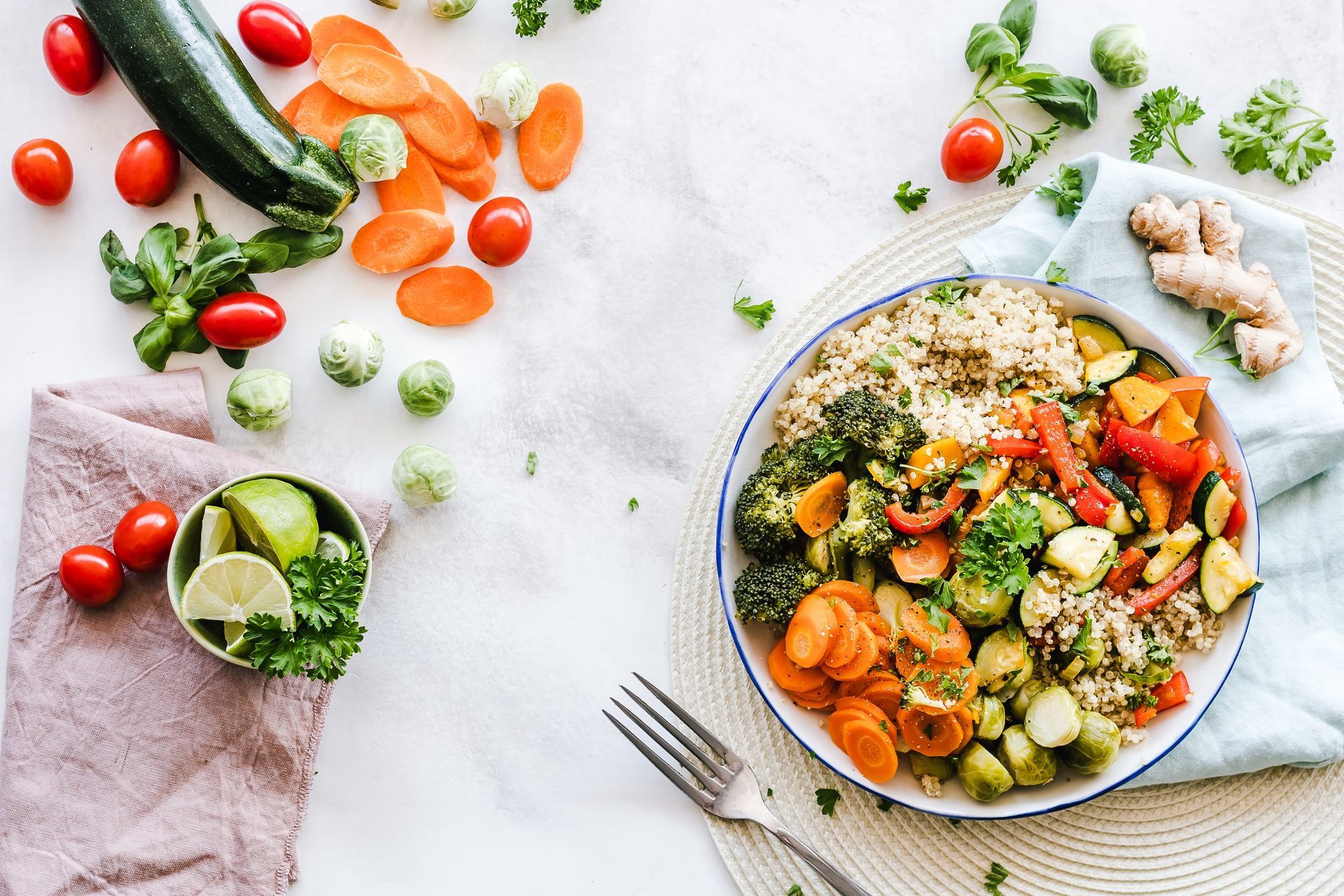 Overhead view of healthy nutrition bowl with fresh vegetables, quinoa, and herbs